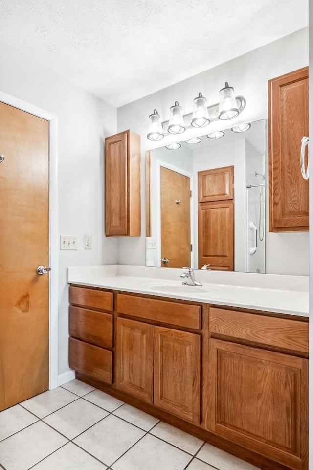 207 Hammitt Dr, Normal, IL 61761 - bathroom featuring tile patterned flooring, vanity, a shower, and a textured ceiling