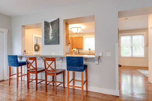 20760 N Florence Ave, Lincolnshire, IL 60069 - kitchen featuring wood finished floors, healthy amount of natural light, and a breakfast bar