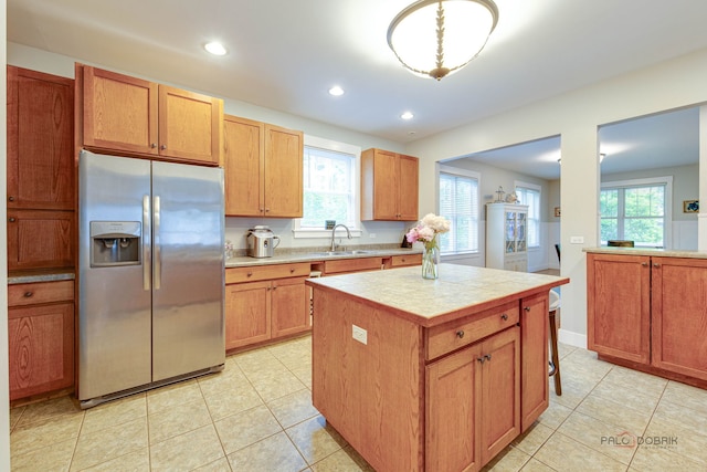 20760 N Florence Ave, Lincolnshire, IL 60069 - kitchen with stainless steel refrigerator with ice dispenser, a kitchen island, light tile patterned floors, plenty of natural light, and recessed lighting