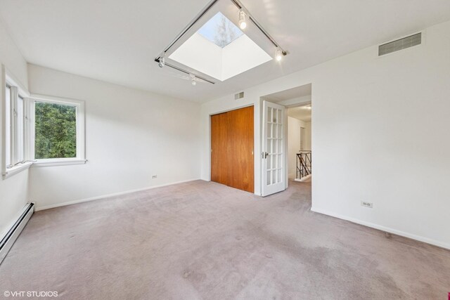 761 Revere Rd, Glen Ellyn, IL 60137 - carpeted empty room featuring track lighting, a baseboard heating unit, and a skylight
