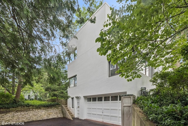 761 Revere Rd, Glen Ellyn, IL 60137 - view of property exterior featuring stucco siding, driveway, stairway, and a garage