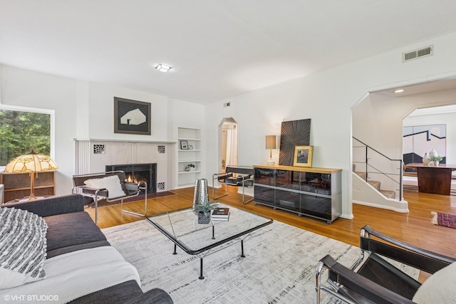 761 Revere Rd, Glen Ellyn, IL 60137 - living room featuring arched walkways, built in shelves, wood finished floors, and a fireplace with flush hearth