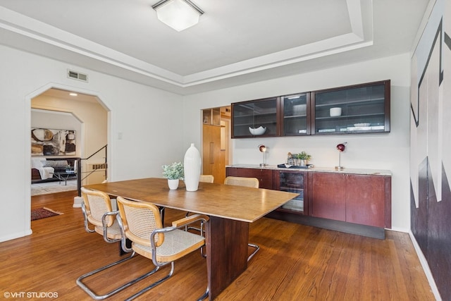 761 Revere Rd, Glen Ellyn, IL 60137 - dining area with a tray ceiling, beverage cooler, wood finished floors, and arched walkways