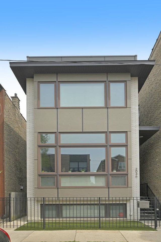 2036 W Huron St, Chicago, IL 60612 - view of side of home featuring a fenced front yard and brick siding