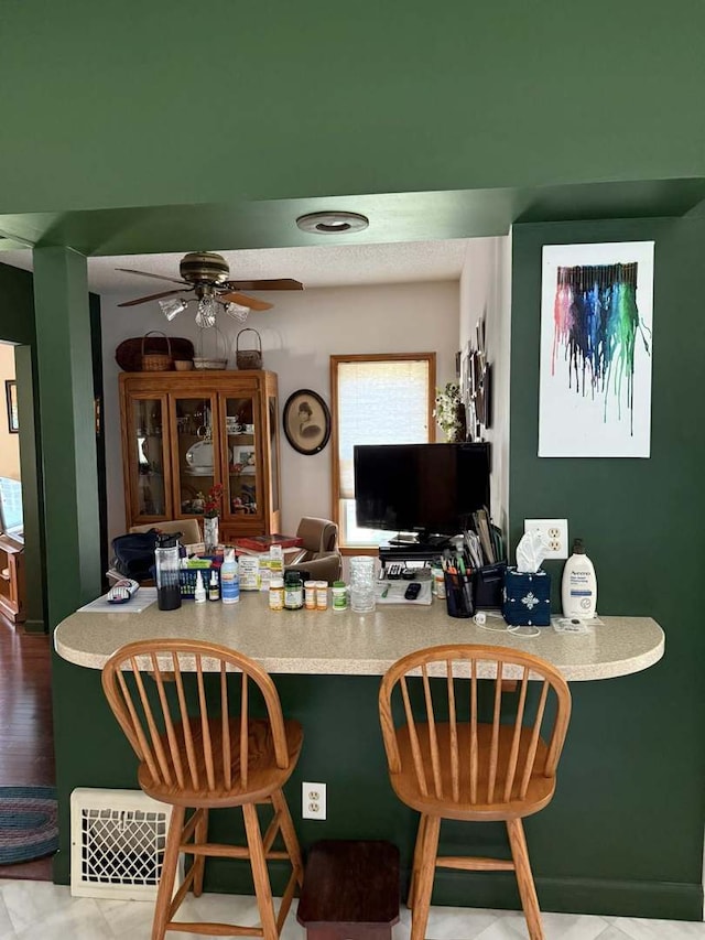 kitchen featuring ceiling fan and a breakfast bar area