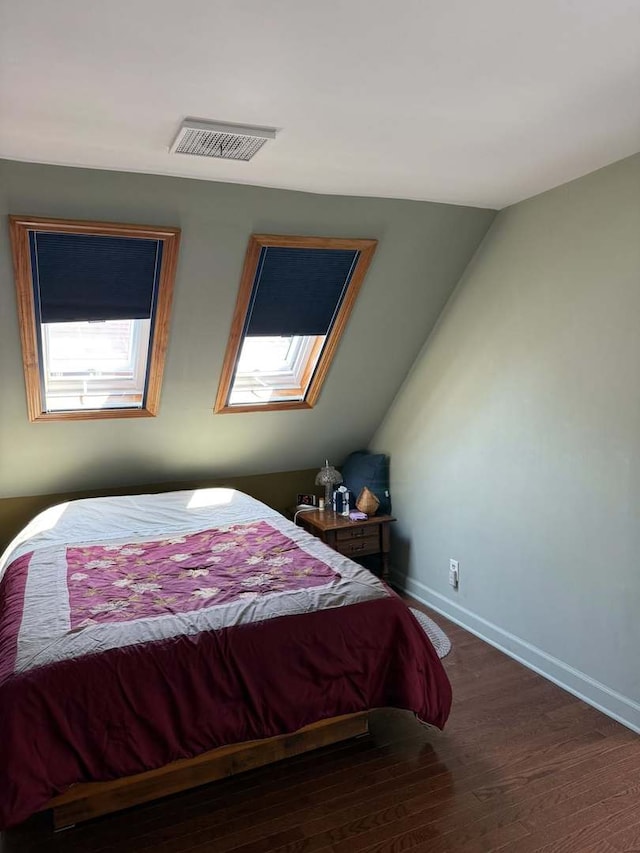 bedroom with wood finished floors and vaulted ceiling