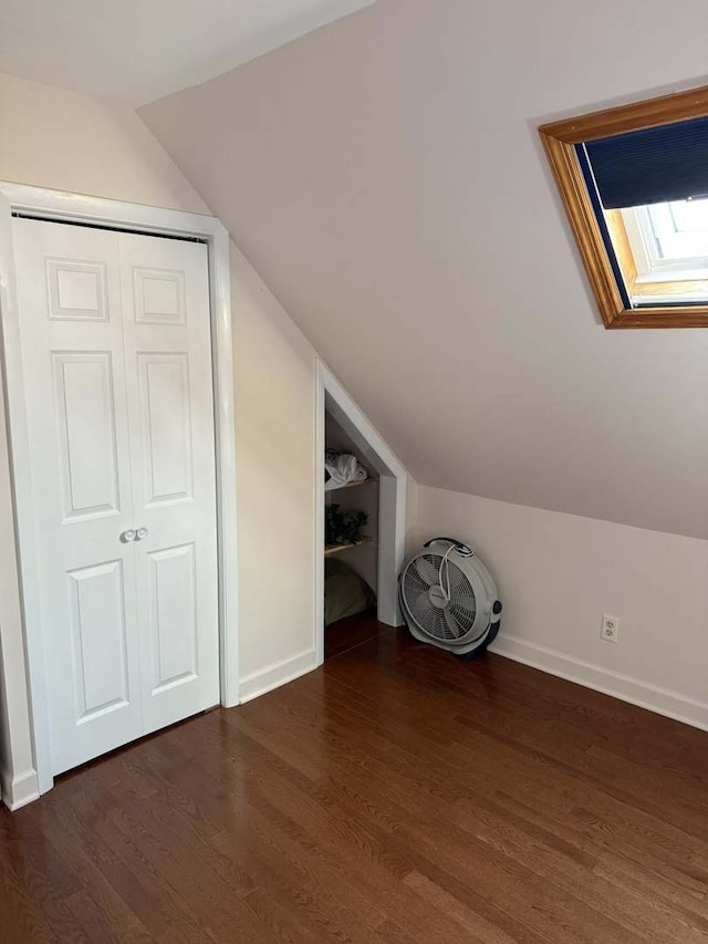 additional living space with vaulted ceiling and dark wood-style flooring