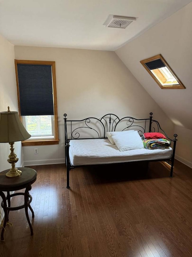 bedroom featuring dark wood-style floors, lofted ceiling, and a skylight