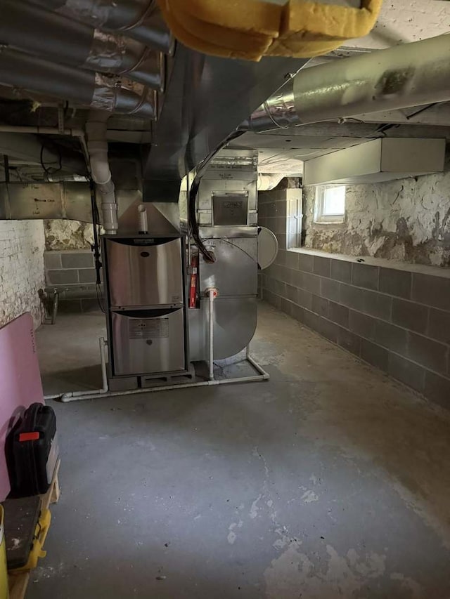 basement featuring heating unit and water heater