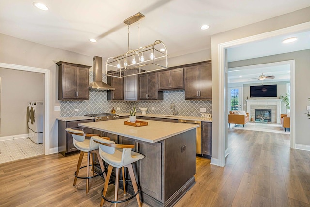 17035 Clover Dr, Orland Park, IL 60467 - kitchen featuring wall chimney exhaust hood, washing machine and clothes dryer, dark brown cabinets, backsplash, and recessed lighting