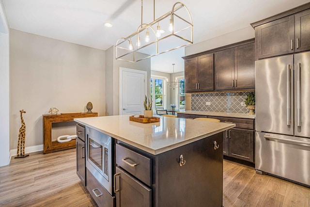 17035 Clover Dr, Orland Park, IL 60467 - kitchen with appliances with stainless steel finishes, dark brown cabinets, light wood-type flooring, a center island, and recessed lighting