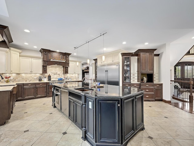 22 Yorkshire Woods, Oak Brook, IL 60523 - kitchen with stainless steel appliances, light tile patterned floors, tasteful backsplash, a kitchen island with sink, and recessed lighting
