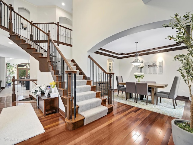 22 Yorkshire Woods, Oak Brook, IL 60523 - stairs with arched walkways, wood-type flooring, crown molding, a towering ceiling, and recessed lighting