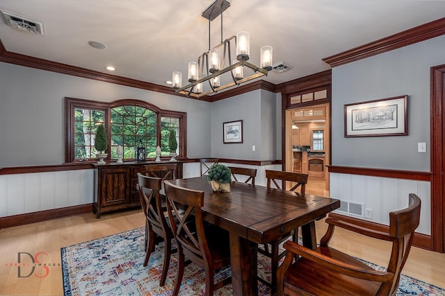 524 E Van Buren St, Ottawa, IL 61350 - dining area featuring crown molding, a wainscoted wall, a chandelier, and light wood finished floors