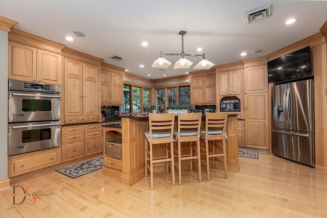 524 E Van Buren St, Ottawa, IL 61350 - kitchen with stainless steel appliances, a kitchen breakfast bar, tasteful backsplash, ornamental molding, and light wood-type flooring
