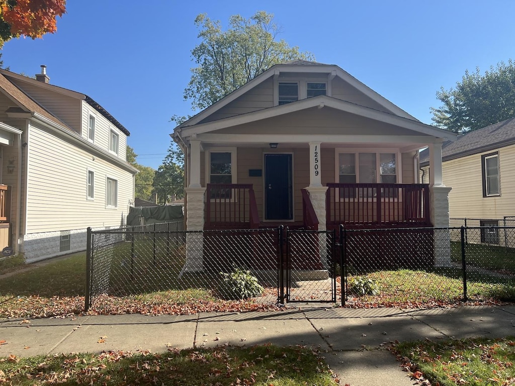 12509 S Emerald Ave, Chicago, IL 60628 - view of front of home with covered porch, a fenced front yard, and a gate