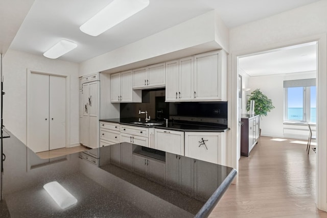 132 E Delaware Pl Unit 5504, Chicago, IL 60611 - kitchen with dark countertops, dishwasher, light wood finished floors, and white cabinets