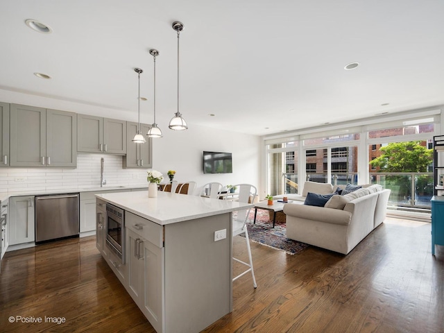 1310 N Western Ave Unit 2N, Chicago, IL 60622 - kitchen with stainless steel appliances, a kitchen breakfast bar, decorative backsplash, dark wood-style floors, and a kitchen island