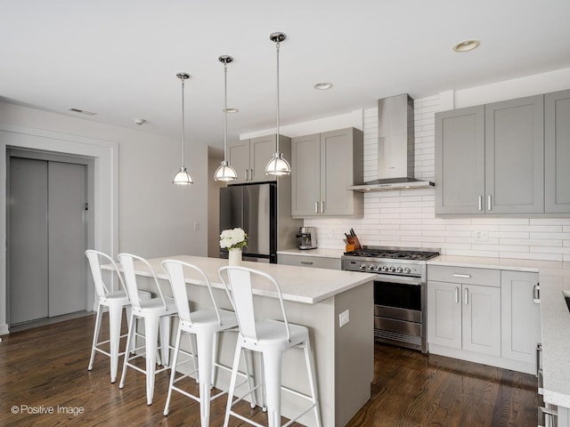 1310 N Western Ave Unit 2N, Chicago, IL 60622 - kitchen featuring stainless steel appliances, wall chimney exhaust hood, gray cabinets, a center island, and backsplash