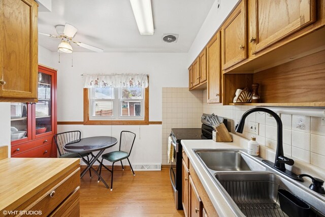 1609 Boeger Ave, Westchester, IL 60154 - kitchen with stainless steel range with electric stovetop, light wood-style flooring, brown cabinetry, and ceiling fan