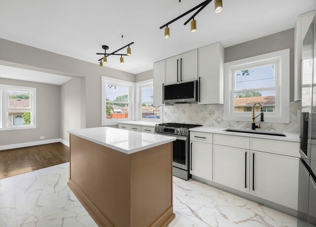 3800 W 82nd St, Chicago, IL 60652 - kitchen with stainless steel range with gas stovetop, light marble finish floors, a chandelier, decorative backsplash, and a center island