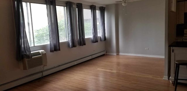 6300 N Sheridan Rd Unit 107, Chicago, IL 60660 - unfurnished room featuring a baseboard heating unit, plenty of natural light, wood finished floors, and a ceiling fan