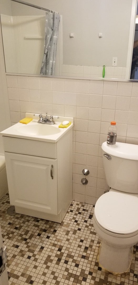 6300 N Sheridan Rd Unit 107, Chicago, IL 60660 - full bath with tile walls, vanity, a shower with curtain, and tile patterned floors