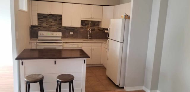 6300 N Sheridan Rd Unit 107, Chicago, IL 60660 - kitchen featuring white appliances, decorative backsplash, dark countertops, and a breakfast bar area