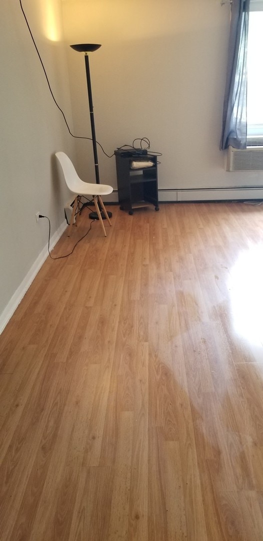 6300 N Sheridan Rd Unit 107, Chicago, IL 60660 - spare room with light wood-style floors and a baseboard radiator