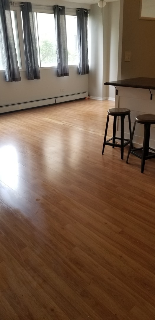 6300 N Sheridan Rd Unit 107, Chicago, IL 60660 - empty room with a baseboard heating unit and light wood-type flooring