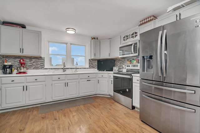 31330 S Seltzer Rd, Wilmington, IL 60481 - kitchen featuring appliances with stainless steel finishes, light countertops, backsplash, light wood-style flooring, and white cabinets