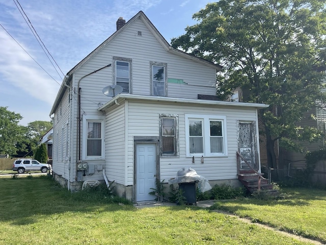 18 E 24th St, Chicago Heights, IL 60411 - rear view of house featuring entry steps, a lawn, and a chimney