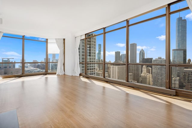 21 E Huron St Unit 4701, Chicago, IL 60611 - unfurnished room featuring a wall of windows, a view of skyline, wood finished floors, and healthy amount of natural light