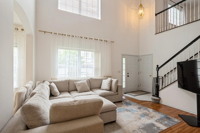 6073 Canterbury Ln Unit 33-5, Hoffman Estates, IL 60192 - living area featuring arched walkways, stairs, a towering ceiling, and hardwood / wood-style flooring