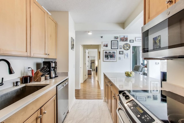 400 N La Salle Dr Unit 1607, Chicago, IL 60654 - kitchen with appliances with stainless steel finishes, light brown cabinetry, light marble finish flooring, a textured ceiling, and light countertops