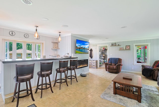 1452 Raymond St, South Elgin, IL 60177 - kitchen with crown molding, plenty of natural light, a kitchen breakfast bar, decorative light fixtures, and light tile patterned floors