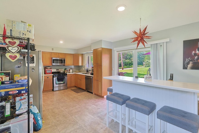 1452 Raymond St, South Elgin, IL 60177 - kitchen featuring stainless steel appliances, light countertops, a breakfast bar area, light tile patterned floors, and recessed lighting
