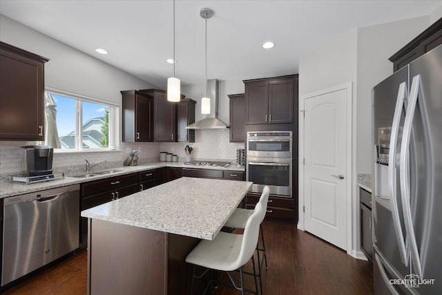 808 Karen Dr, Hampshire, IL 60140 - kitchen featuring stainless steel appliances, wall chimney range hood, dark brown cabinets, tasteful backsplash, and dark wood finished floors