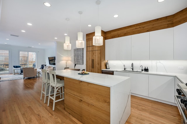 824 W Armitage Ave Unit 2Cd, Chicago, IL 60614 - kitchen with modern cabinets, range, a kitchen island, light wood-type flooring, and recessed lighting
