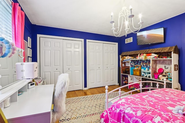 51 Mitchell Cir, Wheaton, IL 60189 - bedroom featuring two closets, a chandelier, and wood finished floors