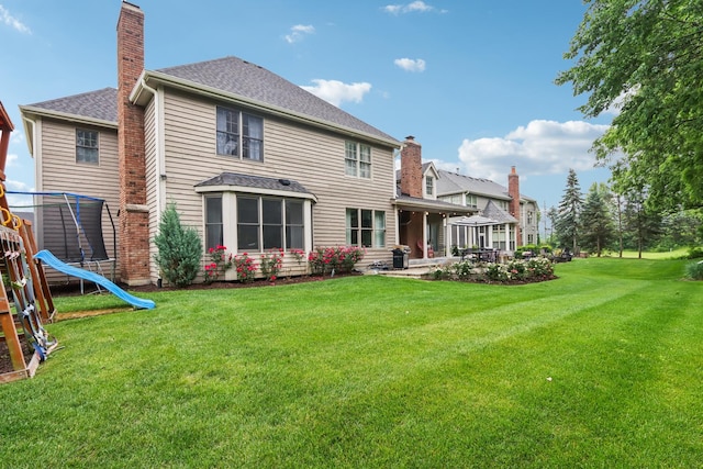 51 Mitchell Cir, Wheaton, IL 60189 - rear view of house with a trampoline, a chimney, a yard, a patio, and roof with shingles