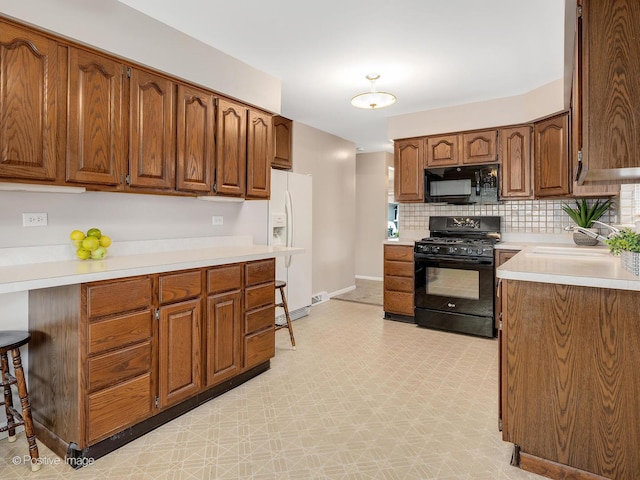 4220 Maple Ave, Brookfield, IL 60513 - kitchen with black appliances, light countertops, backsplash, and brown cabinetry