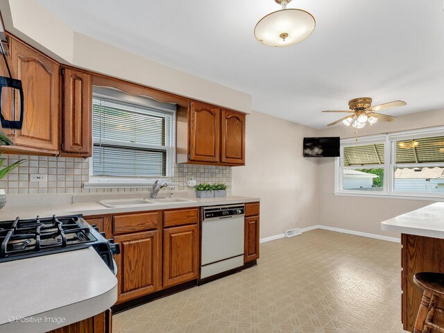 4220 Maple Ave, Brookfield, IL 60513 - kitchen with white dishwasher, light countertops, backsplash, brown cabinets, and healthy amount of natural light