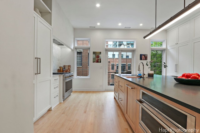 358 W Huron St Unit B, Chicago, IL 60654 - kitchen featuring stainless steel range, light wood finished floors, recessed lighting, dark countertops, and white cabinetry