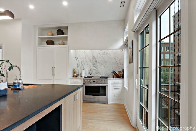 358 W Huron St Unit B, Chicago, IL 60654 - kitchen featuring high end stainless steel range, light wood-style flooring, white cabinets, backsplash, and open shelves