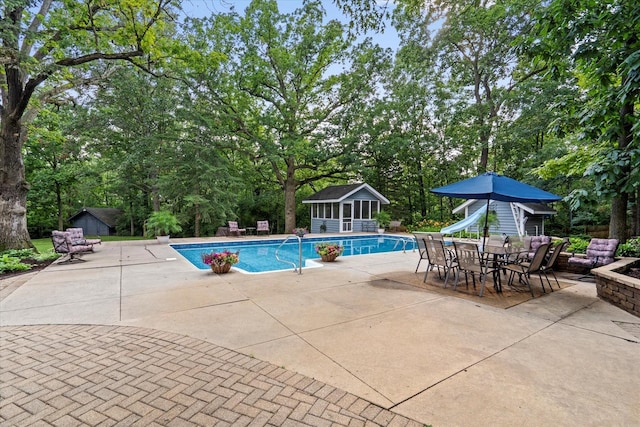 13302 Archer Ave, Lemont, IL 60439 - outdoor pool featuring a patio, a water slide, an outdoor structure, and view of wooded area