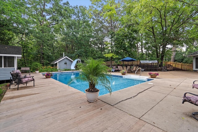 13302 Archer Ave, Lemont, IL 60439 - outdoor pool with a water slide, a patio, a deck, view of scattered trees, and a storage unit