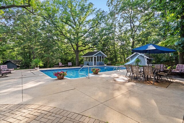 13302 Archer Ave, Lemont, IL 60439 - swimming pool with a water slide, an outdoor structure, a patio area, a storage structure, and view of wooded area
