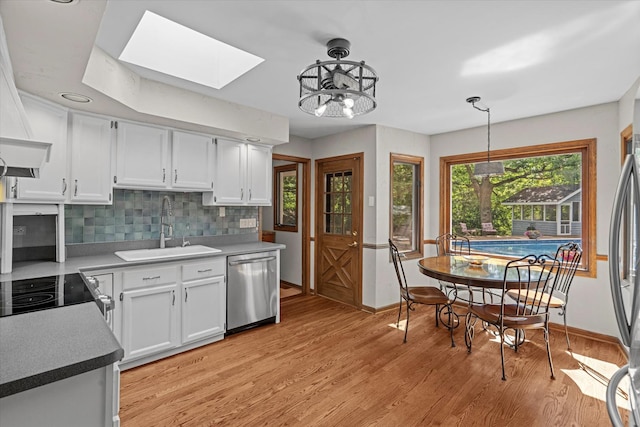 13302 Archer Ave, Lemont, IL 60439 - kitchen with dishwasher, a skylight, decorative backsplash, white cabinetry, and healthy amount of natural light