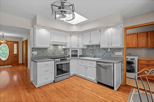 13302 Archer Ave, Lemont, IL 60439 - kitchen with stainless steel appliances, light wood-style floors, white cabinetry, washer / dryer, and backsplash